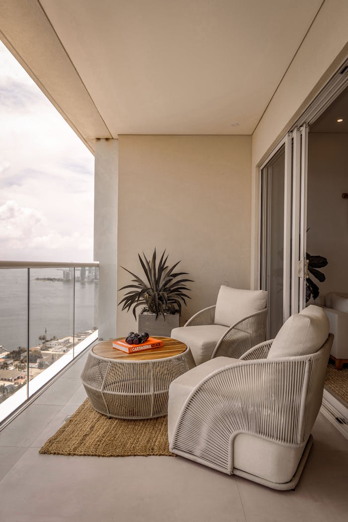 Stylish balcony with modern furniture overlooking a tranquil waterfront view.